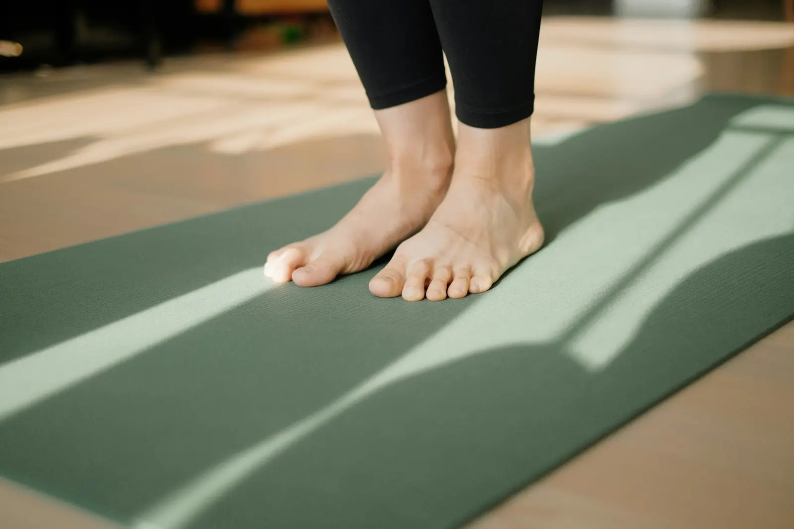Bare feet on a pilates mat in morning light